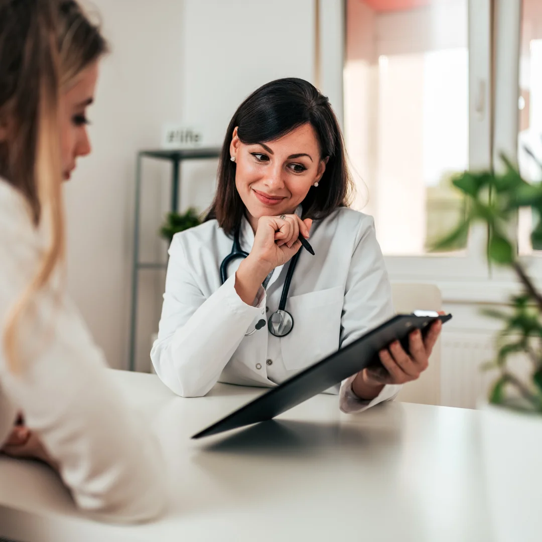 Doctor consulting a patient while reviewing information on a tablet.